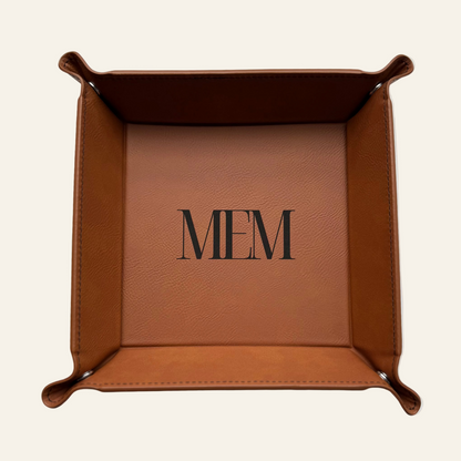 Brown leather tray with monogram on a white surface