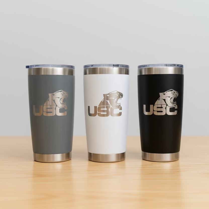 Three insulated tumblers with USC logo on a wooden surface and light gray background